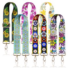 six colorful flowered leashs are lined up in a row and one has a metal hook