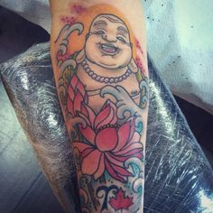 a person with a tattoo on their arm that has an image of a buddha in it