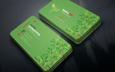 two business cards with green leaves on them, one has the word nature conservation printed on it