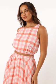 DETAILS   Our Betty Top is the perfect go-to for any sunny day. It features a cropped length, non adjustable straps and an elasticised waistband to keep you stylish and comfortable all day long. With a pink gingham print design to make you stand out from the crowd.   cropped length  round neckline  non adjustable straps  elasticised waistband  gingham print  lined  m aterial - 100% cotton / lining - 100% rayon     SIZING      studio model is 5' 7" and wears a Size S    model stats: bust - 33", w Spring Cotton Crop Top With Elastic Waistband, Summer Crop Top With Elastic Waistband, Spring Beach Crop Top With Elastic Waistband, Spring Crop Top With Elastic Waistband, Spring Crop Top With Elastic Waistband Suitable For Summer, Casual Crop Top With Elastic Waistband For Day Out, Pink Cropped Top For Vacation, Sleeveless Crop Top With Elastic Waistband For Spring, Summer Beach Crop Top With Elastic Waistband