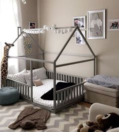 a baby's room with a giraffe bed in the corner and pictures on the wall