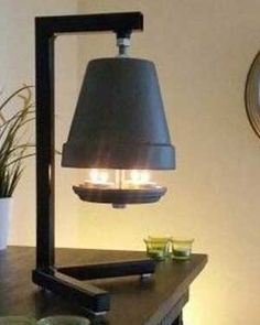 a lamp that is sitting on top of a table next to a potted plant