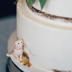 a close up of a white cake with flowers on the top and small figurines