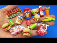 a hand holding a bunch of toy food and condiments in it's palm