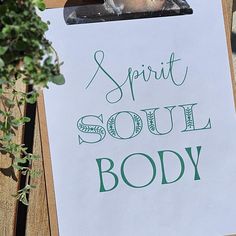 a clipboard with the words spirit soul body written on it next to a potted plant