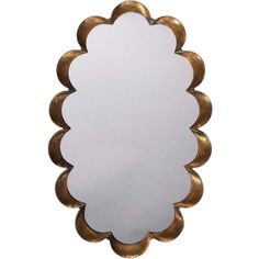 a mirror that is sitting on top of a white wall with gold trimmings