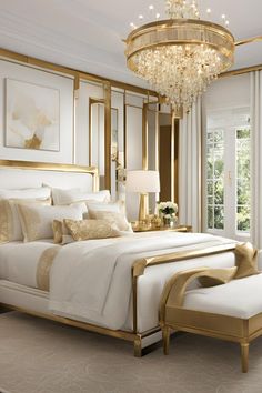 a large white bed sitting under a chandelier in a bedroom next to a window