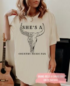 "Shes A Country Music Fan, Vintage Western T-shirt, Trendy tee, Cowgirl Country Shirt, Country Concert Tee, Western Graphic Tee for Women This comfortable T-shirt is a perfect gift idea as a birthday gift, Halloween party, or any special occasion for your best friends or your family members or anyone who you love and a really great way of putting a smile on their faces. 👕H O W TO O R D E R 1️⃣ Please, check and review all the photos. 2️⃣ Choose your T-shirt size and color. 3️⃣ Click add to cart Trendy Crew Neck T-shirt For Country Concerts, Fan Apparel Short Sleeve Tops For Concert, Fan Apparel Tops For Concert With Short Sleeve, Spring Crew Neck T-shirt For Country Concerts, Summer Crew Neck T-shirt For Country Concerts, Spring Fan Merchandise T-shirt, Spring Music-themed Crew Neck T-shirt, Summer Concert Cotton T-shirt, Spring Music-themed T-shirt For Music Festival