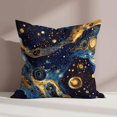 a blue and gold pillow sitting on top of a white bed