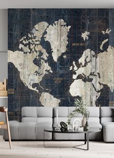 a couch sitting in front of a wall with a world map on it's side