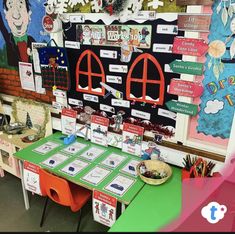 a table with many different items on it in front of a bulletin board and wall