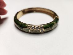 Clamper bracelet fluid shades of green with rhinestone accents.  Excellent condition. It's 2 5/16" across. Formal Green Enamel Jewelry, Green Jeweled Bangle Bracelets, Green Enamel Bangle, Green Metal Bangle Jewelry, Adjustable Green Enamel Jewelry, Elegant Green Metal Cuff Bracelet, Green Metal Bangle For Gift, Green Metal Bangle As A Gift, Green Metal Bangle As Gift