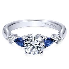 a white gold engagement ring with blue sapphire stones on the side and diamond accents around the band