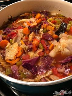 a pot filled with lots of vegetables on top of a stove