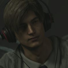 a young man wearing headphones and looking at the camera