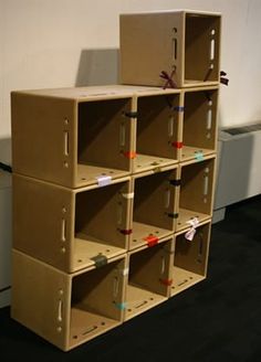 several cardboard boxes stacked on top of each other in front of a white wall and black floor