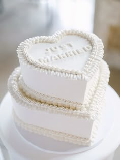 a white heart shaped cake sitting on top of a table