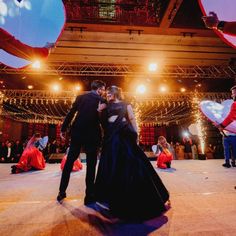 a couple dancing on the dance floor in front of an audience at a wedding reception