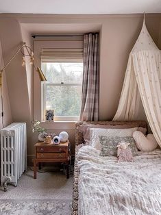 a bed room with a neatly made bed next to a window and a radiator