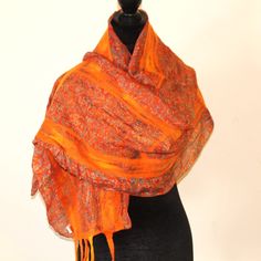 Stay cozy and stylish with this beautiful handmade shawl, crafted from a luxurious blend of recycled silk and merino wool. Soft and  unique piece of textile art features a bold, colorful design that is sure to turn heads. The shawl is made using a felting technique that involves layering silk and wool fibers and wet-felting them together by hand. This process creates a dense, soft fabric that drapes beautifully and is incredibly warm and cozy.  Measuring approximately 70 inches length and 12 inches width,  this shawl is large enough to wrap around your shoulders or wear as a scarf. It's perfect for adding a pop of color to any outfit, and the one-of-a-kind design ensures that you'll stand out from the crowd. Whether you're looking for a special gift for a loved one or a unique addition to Bohemian Shawl Scarf With Natural Dye, Bohemian Shawl Scarves With Natural Dye, Bohemian Orange Silk Dupatta, Handmade Wool Scarves In Bohemian Style, Bohemian Wool Scarves Handmade, Bohemian Handmade Wool Scarves, Handmade Silk Bohemian Shawl, Artisan Shawl For Fall, Bohemian Silk Scarves One Size