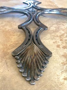 an ornate metal object sitting on top of a marble countertop in the shape of a cross