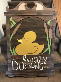 a wooden sign that says the snuggley duckling on it's side