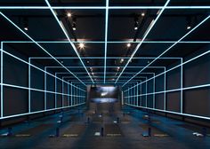 an empty room is lit up with blue lights and white squares on the floor,