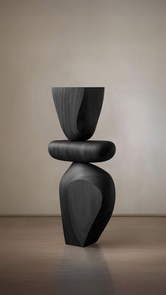 a black sculpture sitting on top of a wooden floor