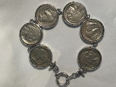 a coin bracelet is shown on a white background with silver coins in the middle and sides