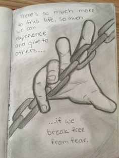 an open book with a drawing of a person's hand holding a pencil and writing on it