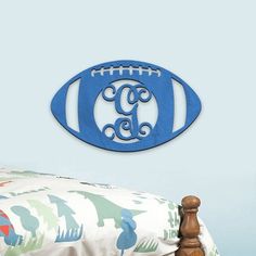 a football shaped monogrammed wall hanging above a bed