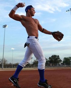 a man with no shirt on holding a baseball mitt in his right hand and wearing white pants