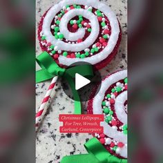 two decorated christmas lollipops with green and red ribbons