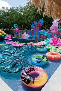 inflatable floats are lined up on the edge of a swimming pool as decorations