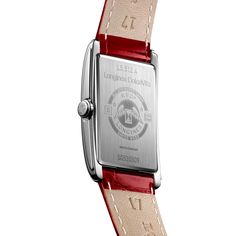 The Longines DolceVita Collection watch featuring a 23mm rectangular case in stainless steel, sapphire crystal, red alligator leather strap with buckle and quartz movement. Silver tone dial with blue hands and Roman numeral indexes. Small seconds subdial and End of Life (E.O.L.) feature. Water resistant up to 30 meters. Luxury Red Leather Watch, Classic Red Leather Watch, Timeless Red Leather Watch, Classic Red Watch With Leather Strap, Modern Red Rectangular Watch, Business Rectangular Watch With Date Indicator, Modern Red Watch With Rectangular Dial, Timeless Red Watches With Rectangular Dial, Classic Red Watch Accessories With Date Indicator