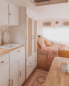 a kitchen with a sink, counter and bed in it