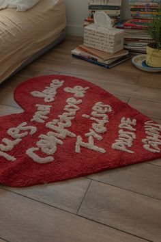 two heart shaped rugs with the words happy birthday written on them in front of a bed