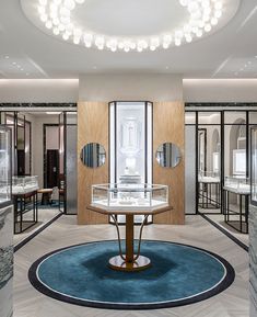 the inside of a jewelry store with mirrors on the wall and round table in the center