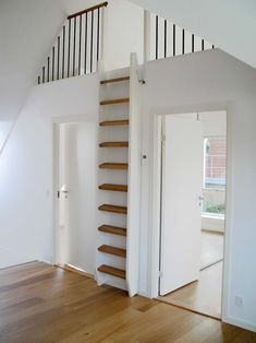 an empty room with stairs and hard wood flooring