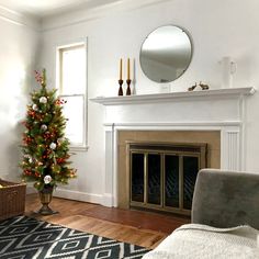 a living room with a christmas tree in the corner and a mirror on the wall