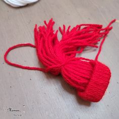 a red piece of yarn is laying on the floor