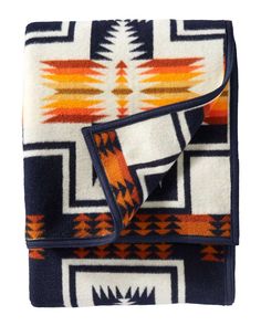 a blanket with an orange, blue and white pattern on the bottom is folded up