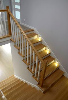 an empty staircase with wooden handrails and white railing