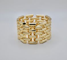 This Vintage-Inspired Gold Bracelet is a modern homage to the elegance and timeless design of the 1930s-1940s era. Drawing inspiration from a piece that graced the pages of Vogue in a full-page ad in 1941, this bracelet captures the essence of vintage glamour with a contemporary twist. Crafted with meticulous attention to detail, this exquisite piece features distinctive tubed bar links, a nod to the retro style that defined an era of unparalleled elegance. The gold construction emanates a warm, Gold-tone Bracelets With Rectangular Links For Formal Occasions, Timeless Formal Gold Bracelet, Yellow Gold Metal Bracelets For Evening, Formal Flexible Yellow Gold Cuff Bracelet, Classic Metal Bracelets For Evening, Classic Flexible Cuff Bracelet For Formal Occasions, Modern Yellow Gold Bracelet For Evening, Classic Yellow Gold Bracelets For Evening, Classic Yellow Gold Bracelet For Evening