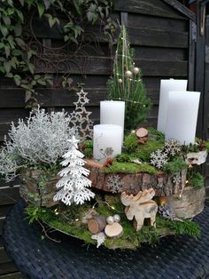 a table topped with candles and plants covered in moss