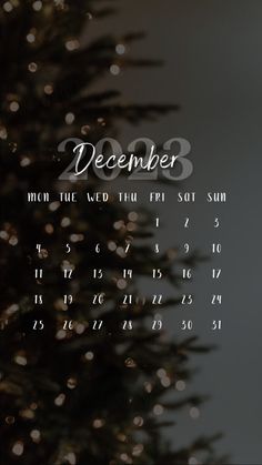 the december 2013 calendar is displayed in front of a christmas tree with lights on it