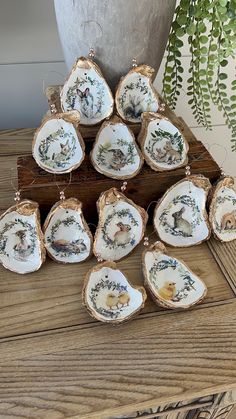 twelve pieces of porcelain sitting on top of a wooden table next to a potted plant