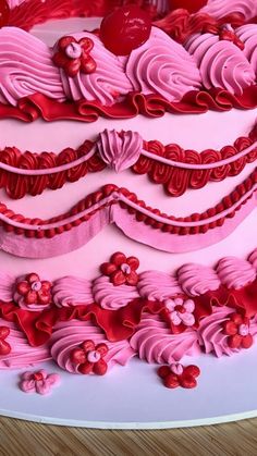 a pink cake with red icing and hearts on it