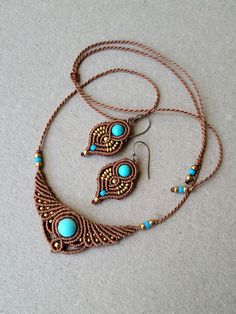 a necklace and earring set with turquoise beads on a white surface in the shape of an owl