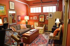 a living room filled with furniture and pictures on the wall